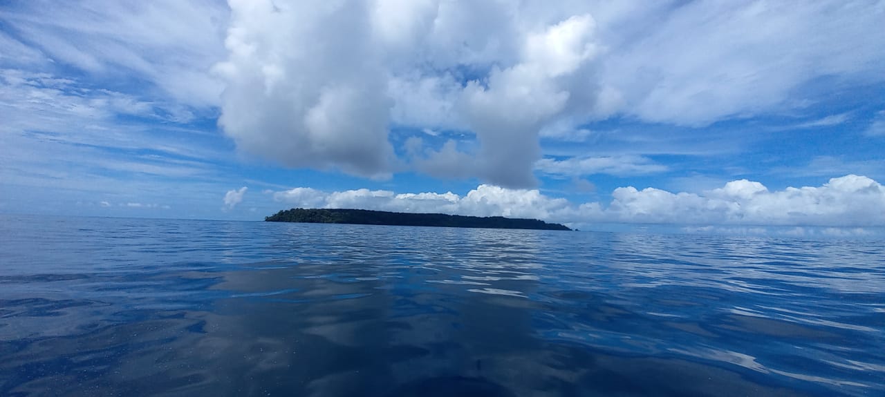 Vista de Isla del Caño desde el mar bajo nubes cumulus